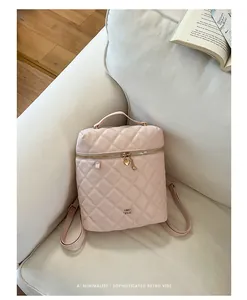 Zaino in pelle trapuntata rosa su un divano bianco con un libro vintage, stile moderno.