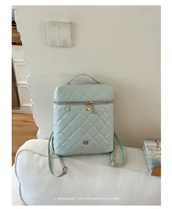 Dettaglio dello zaino trapuntato azzurro con elegante ciondolo a cuore sulla zip dorata