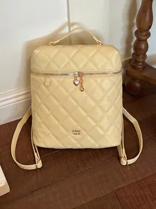 Elegante zaino trapuntato in pelle crema da donna con cerniera a cuore dorata e catena