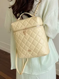 Zaino trapuntato color crema da donna con elegante catena e dettagli dorati.