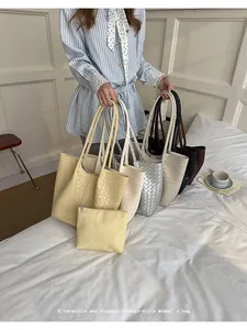 Elegant woven faux leather tote bags in multiple colors in a cozy bedroom setting