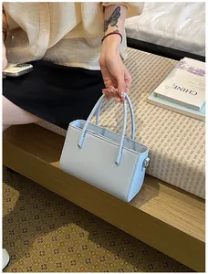 Minimalist pale blue small tote bag with slim top handles and smooth PU leather finish