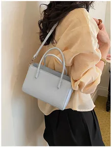 Elegant light blue chic handbag for women in office casual style on a yellow pleated top