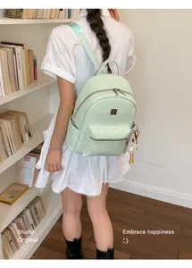 Detailed view of a stylish mint green woven fashion backpack on a model in a library