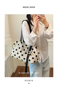 Detailed view of the stylish polka dot tote bag worn by a model