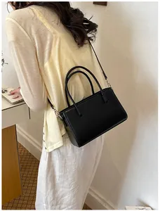 Detail shot of a minimalist black handbag worn as a stylish crossbody bag for women