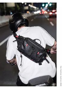 Black tactical sports sling bag worn by a motorcyclist in a night street urban scene