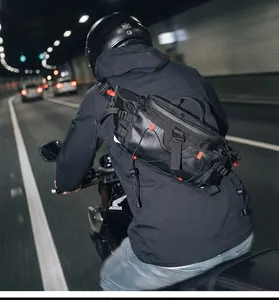 Rear view of a man riding a motorcycle with a black waterproof sports crossbody chest bag.