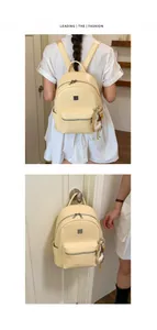 Cream woven texture backpack for women shown on model and hanging on a door