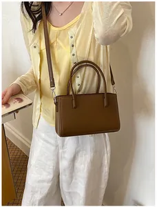 Stylish brown minimalist handbag for women, shown worn with a casual summer outfit.