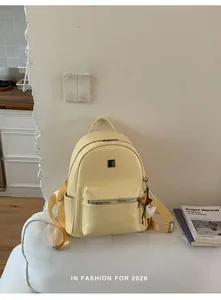 Large yellow textured faux leather backpack with woven pattern on a white couch