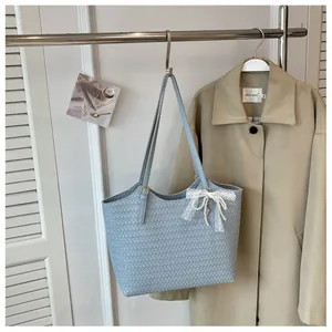 Sac cabas tissé bleu clair premium avec breloque nœud en dentelle sur un portant