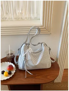 Detailansicht der großen hellblauen Hobo-Tasche mit weißen Punkten und Perlenanhänger
