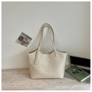 Détail d'un sac cabas tressé crème de qualité supérieure avec des bretelles réglables.