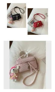 Detailed view of stylish pink polka dot crossbody bag with cute sheep plush charm