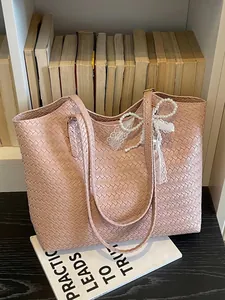 Grand sac cabas rose tissé avec un nœud en dentelle perlée pour le style d'été.