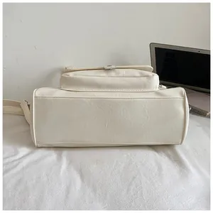 Bottom detail view of a large capacity off-white PU leather shoulder tote bag for women