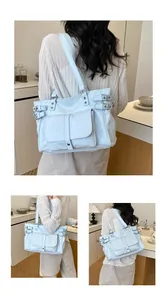 Fashionable light blue large capacity commuter tote bag carried by a model indoors