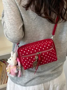 Red and white polka dot crossbody bag for women with cute charms and thin strap