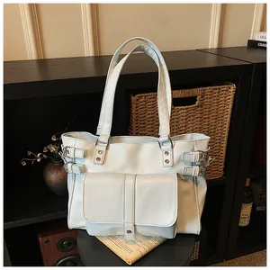 Large capacity white tote bag with front pocket and buckle details in a home setting
