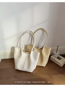 Close-up of elegant white and beige woven tote bags for a stylish commuter look