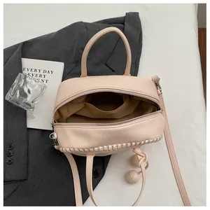 Detailed view of the interior and pebble texture of this pinkish-beige Boston bag.