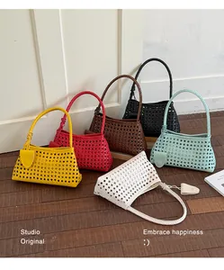 Collection de six sacs à bandoulière tissés colorés disposés sur un parquet en bois