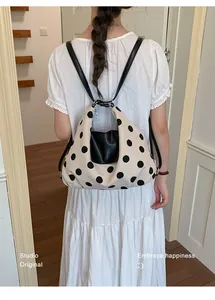 Primo piano di uno zaino a pois versatile da donna indossato in un ambiente casual