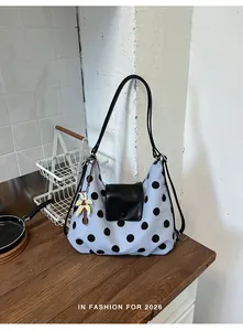Borsa a pois azzurra con patta in pelle nera e ciondolo a forma di palma.