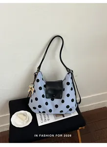 Borsa a tracolla blu a pois multifunzionale su sgabello nero per uno stile di vita.