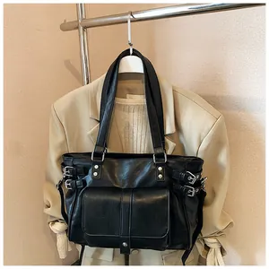 Detail of large black commute tote bag with silver buckle accents and front pocket