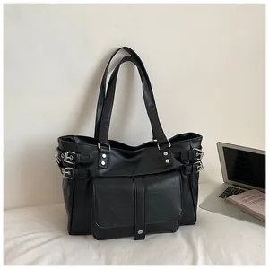 Large black commuter tote bag with silver buckle details shown in a lifestyle setting