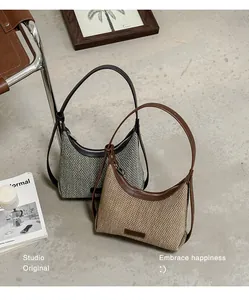 Close-up of stylish woven underarm hobo bags in brown and grey in a lifestyle setting