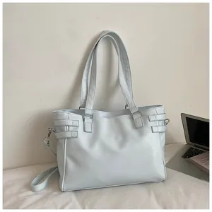 Detail shot of a stylish large capacity pale blue commuter tote bag on a neutral surface
