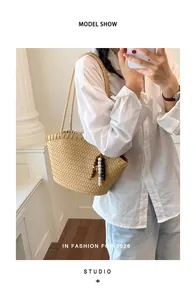 Elegante bolso tote de paja tejida con adornos de cuentas lucido por una modelo asiática