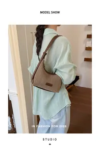 Detailed shot of a woven khaki shoulder bag styled with a light green shirt on a model.