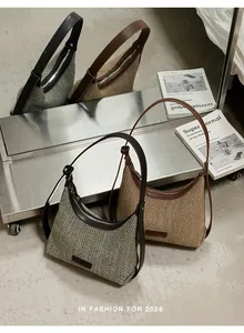 Woven underarm shoulder bags in grey and tan displayed in a modern scene