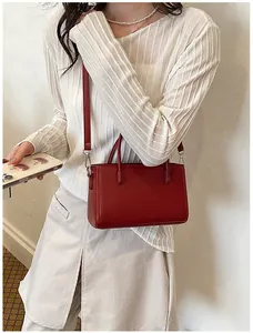 Elegant small red rectangular leather shoulder bag for women shown in lifestyle scene