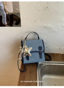 Mochila pequeña de mezclilla moderna para mujer con dije de estrella y borla plata