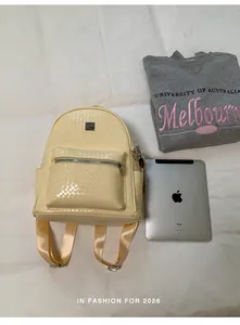 Detailed view of the yellow woven backpack showing its size next to a tablet.