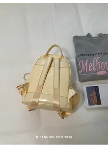 Back view of a cream-colored woven fashion backpack for women with adjustable straps.