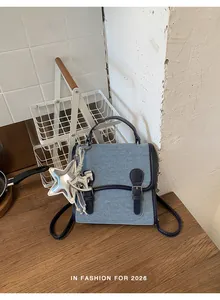 Detalle de una elegante mochila vaquera azul para mujer con dijes de estrella y caballo