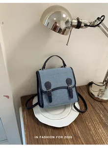 Primer plano de una mini mochila de mezclilla azul claro con adornos de cuero
