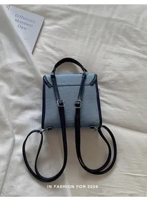 Vista posterior detallada de una mochila vaquera azul claro con correas azul oscuro