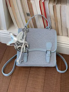 Mochila azul claro con textura denim y colgantes decorativos de estrella y caballo mujer