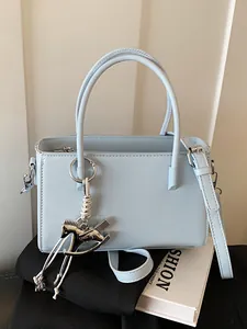 Elegant light blue women's handbag featuring a silver rocking horse charm for daily use