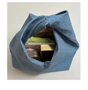 Detailansicht der großen Kapazität einer Denim-Knoten-Handtasche mit Regenschirm innen.