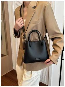 Close-up of a stylish black pebbled leather bucket handbag with twin handles