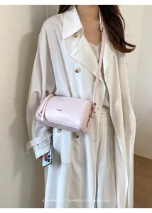 Modell trägt eine hellrosa minimalistische Boston-Tasche für einen Retro-Look.