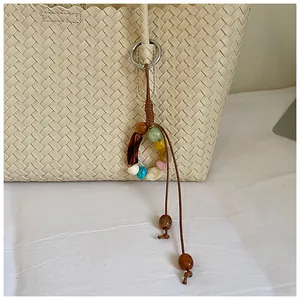 Gros plan d'un sac fourre-tout tissé rétro avec un pendentif en perles colorées